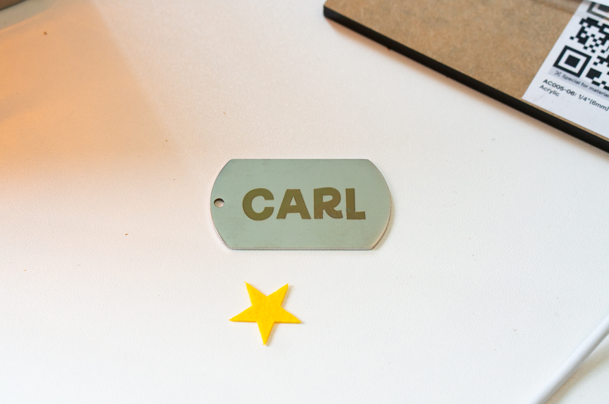 Engraved metal dog tag personalized with the name "Carl" created with the xTool F2 laser engraver.