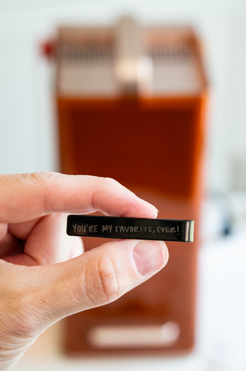 Close-up of custom handwritten message laser engraved onto a metal jewelry piece